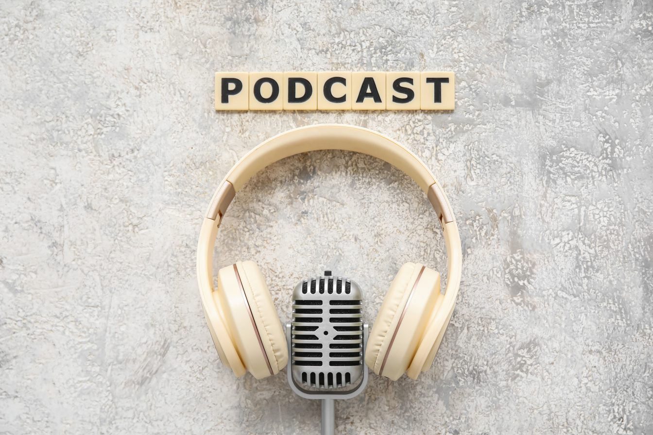 Word PODCAST, Headphones and Microphone on Grunge Background